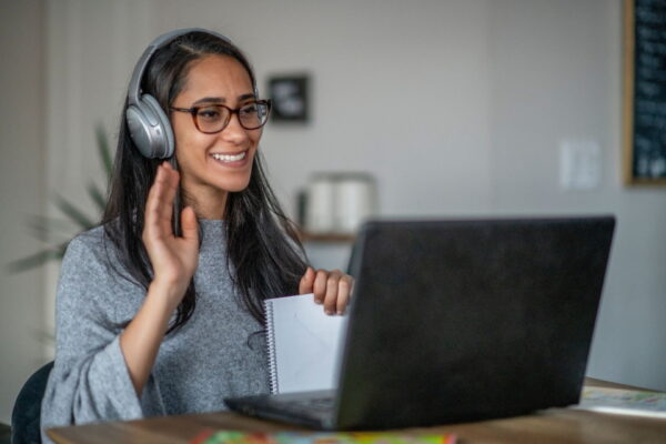 Woman leanring spanish in front of the computer with headphones on